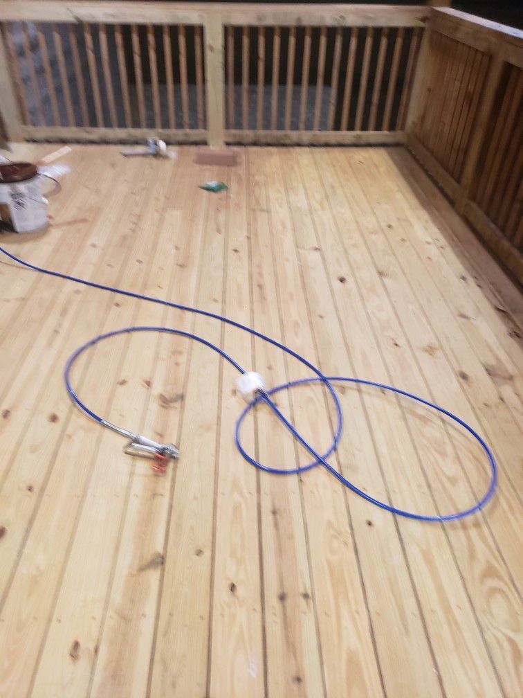 A blue hose is laying on a wooden deck