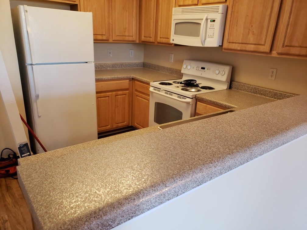 A kitchen with a refrigerator , stove , and microwave.
