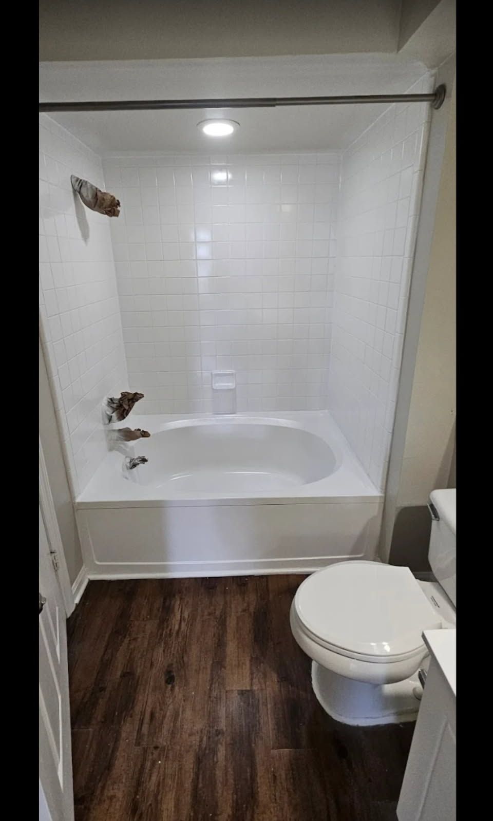 A bathroom with a tub , toilet and shower.