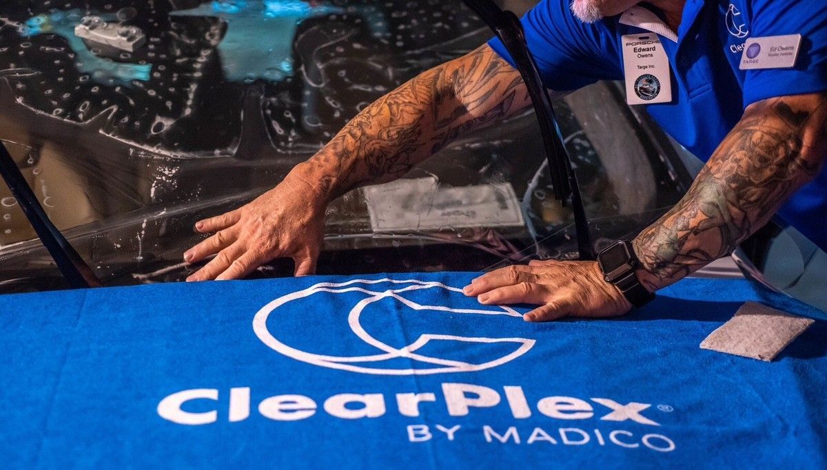 ClearPlex film on a car windshield, logo on blue cloth
