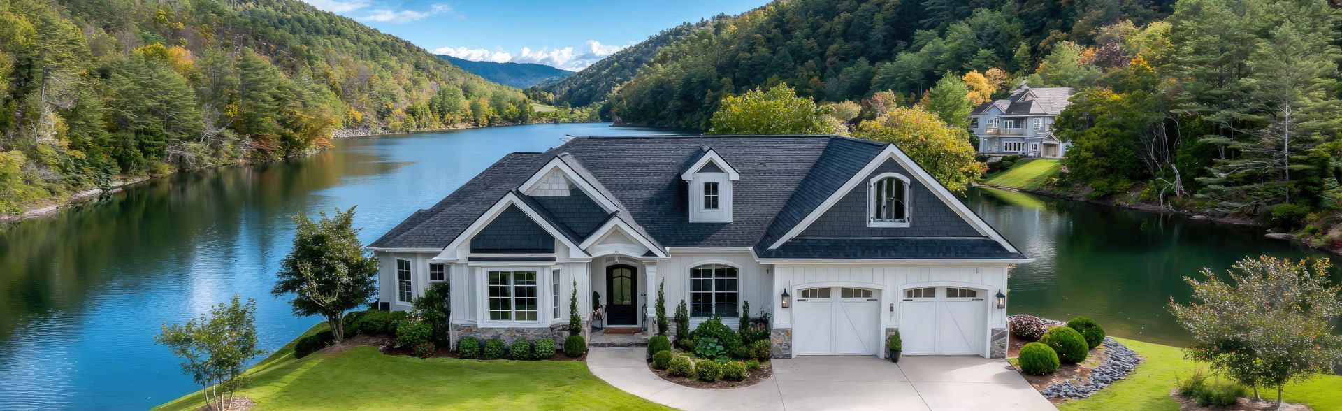 Green Craftsman home with a brick chimney, yellow front door, and manicured lawn.