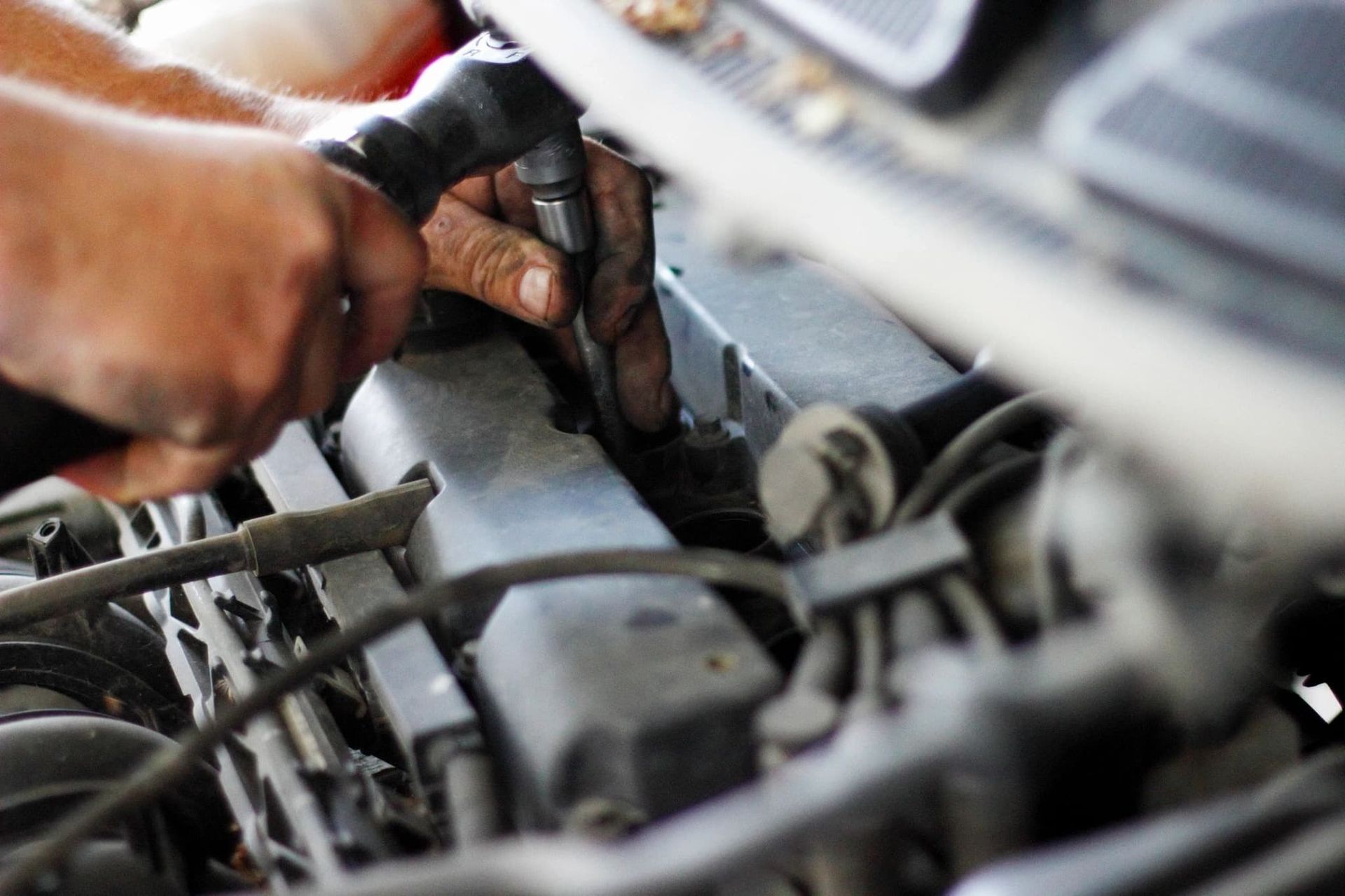 Man is Working on a Car Engine With a Screwdriver — Automotive All Stars Car Service and Repair in Logan Reserve, QLD