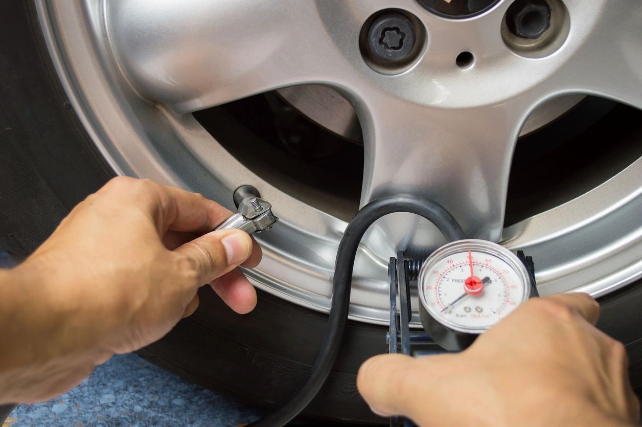 A Person is Checking the Pressure of a Tire With a Gauge — Automotive All Stars Car Service and Repair in Boronia Heights, QLD