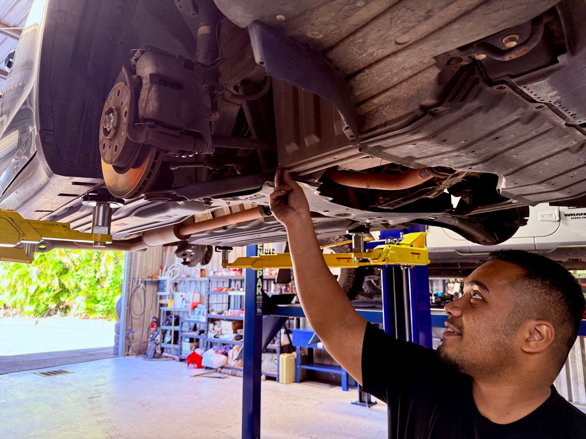 A Mechanic is Working on a the underside of a Car — Automotive All Stars Car Service and Repair in Boronia Heights, QLD