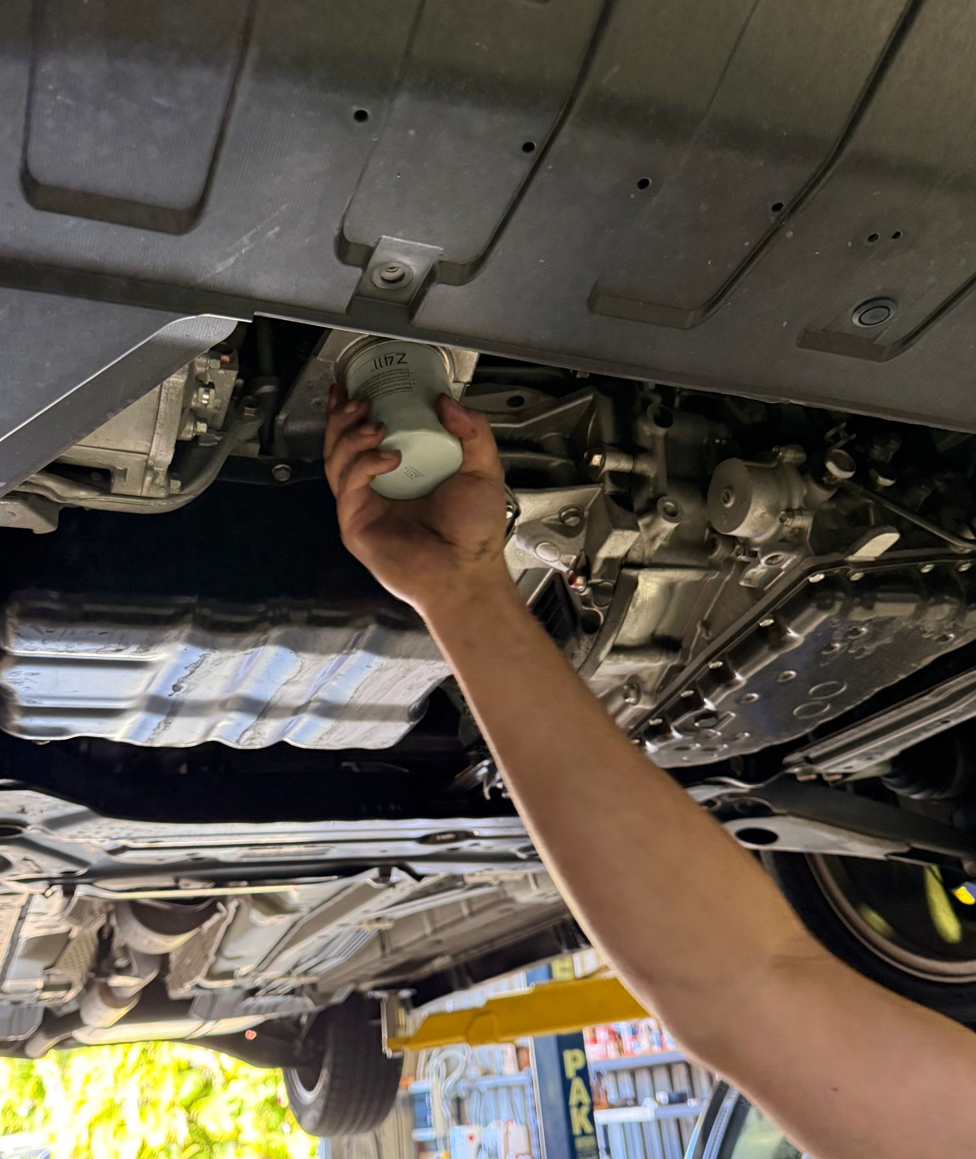A Mechanic's hand Servicing the underside of a Car — Automotive All Stars Car Service and Repair in Boronia Heights, QLD