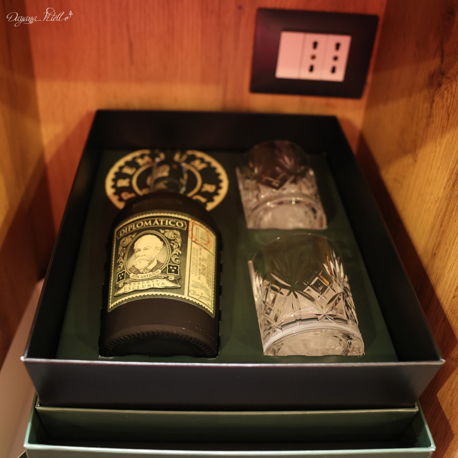 Un set regalo che comprende una bottiglia di rum Diplomatico e due bicchieri di cristallo, il tutto racchiuso in un'elegante confezione regalo verde scuro.