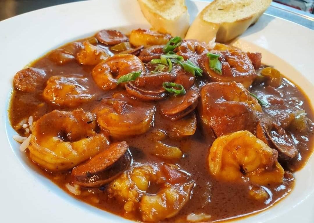 Shrimp and sausage gumbo in white bowl with toasted bread.