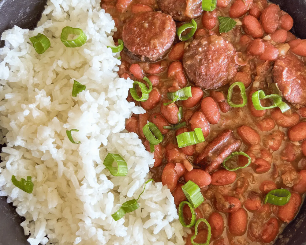 Red beans and sausage with white rice, garnished with green onions.