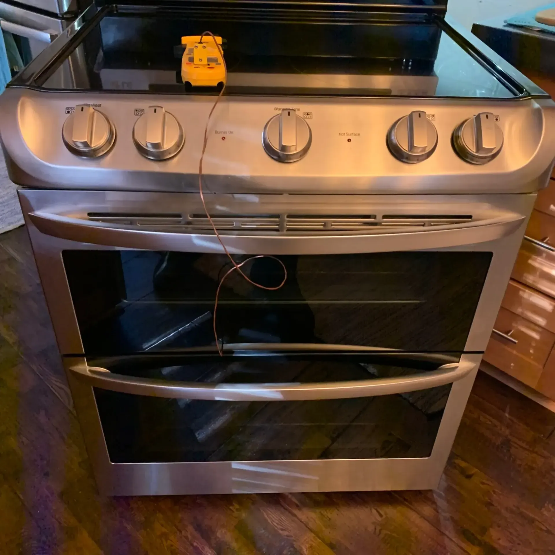 Appliance Tech- A stainless steel stove with a yellow thermometer attached to it
