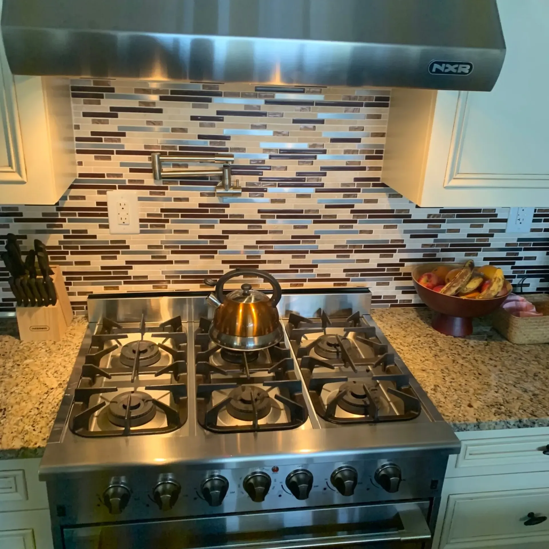 Appliance Tech- A stainless steel stove with a kettle on it