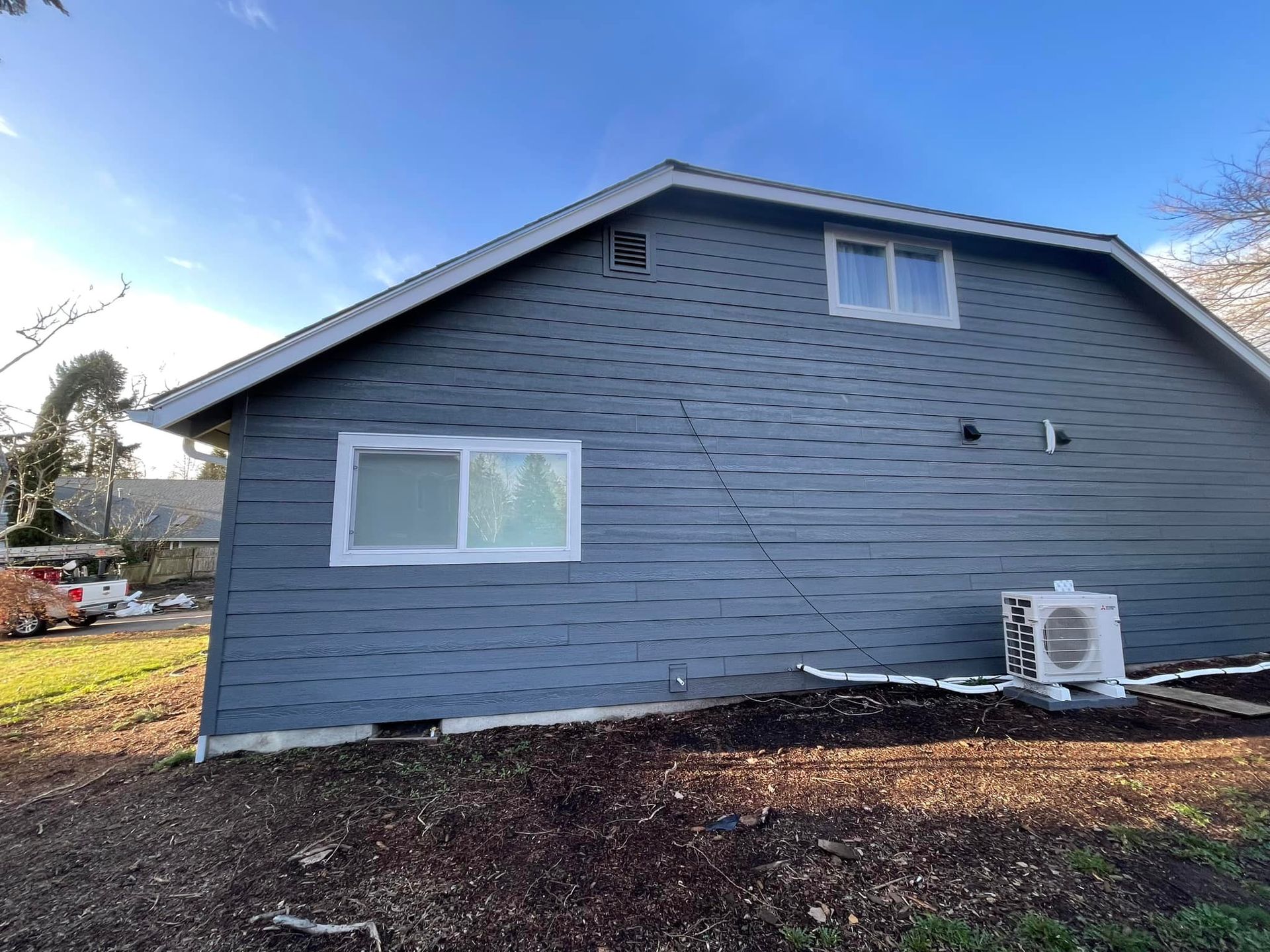 The side of a house with a lot of windows and a roof.