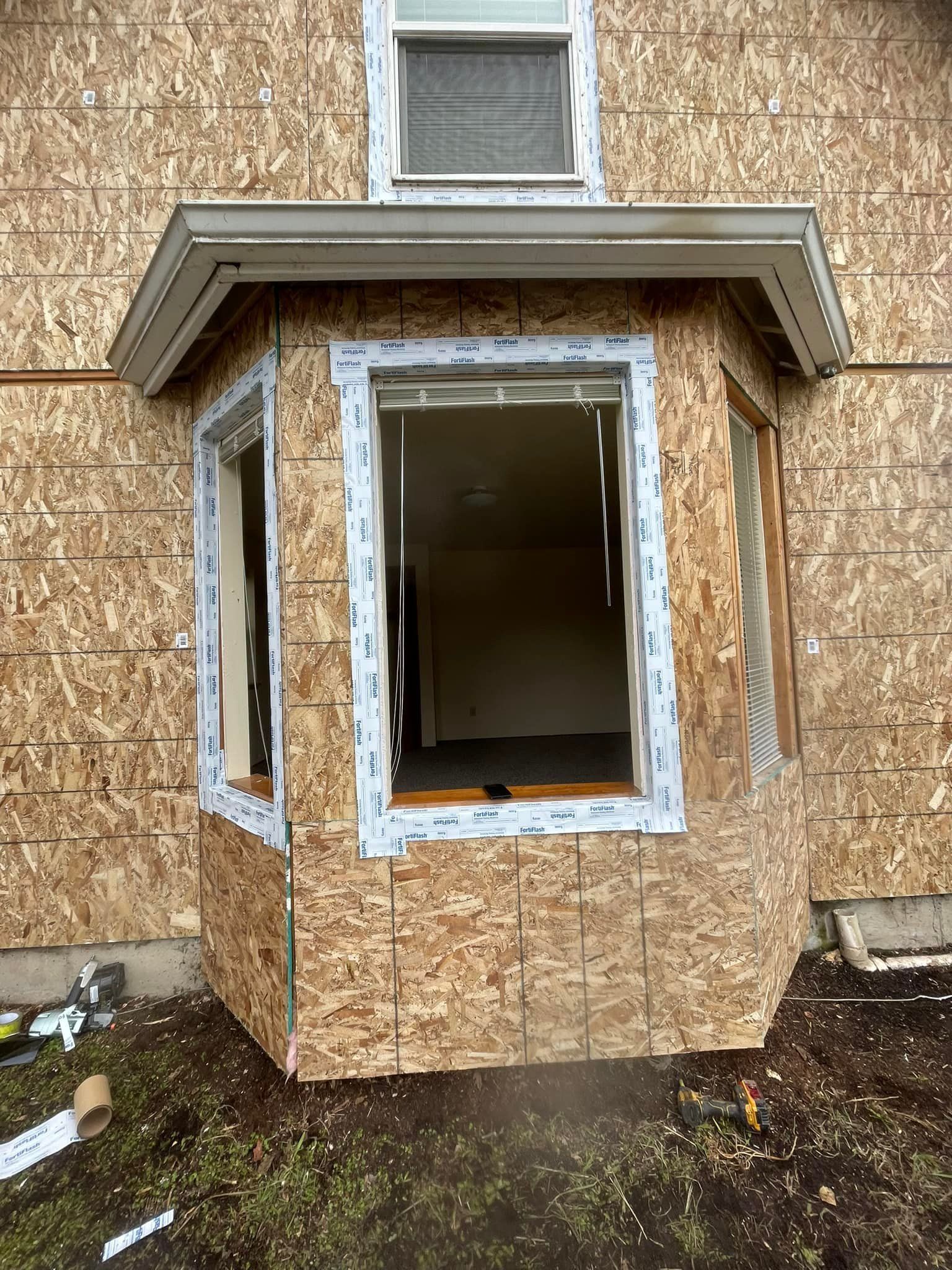 A house with a bay window is being built.