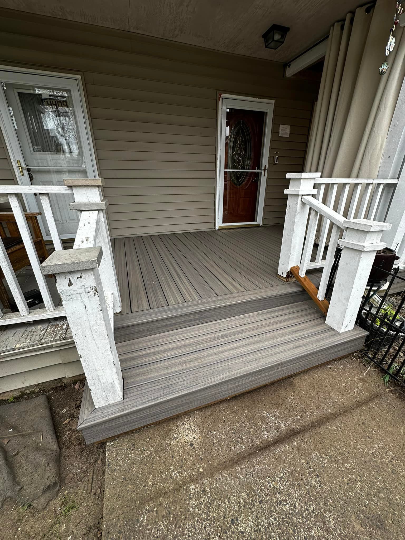 A porch with stairs leading up to the front door of a house.
