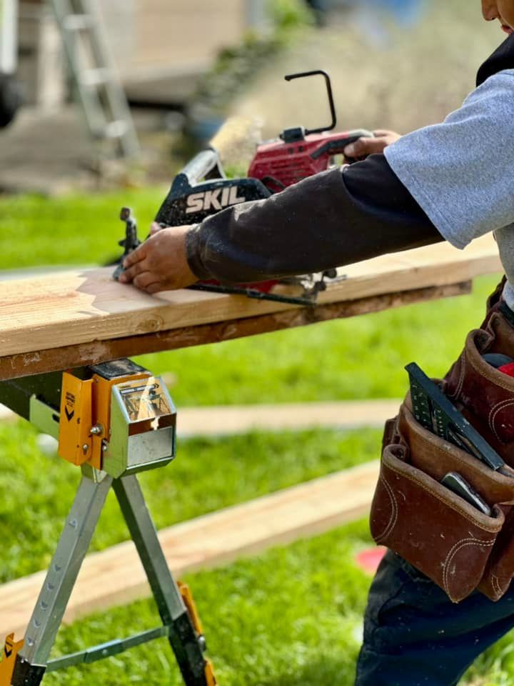 A man is using a circular saw to cut a piece of wood.