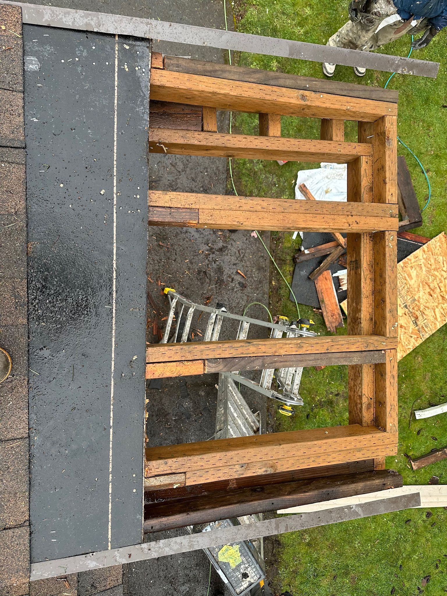 An aerial view of a wooden structure being built on top of a roof.