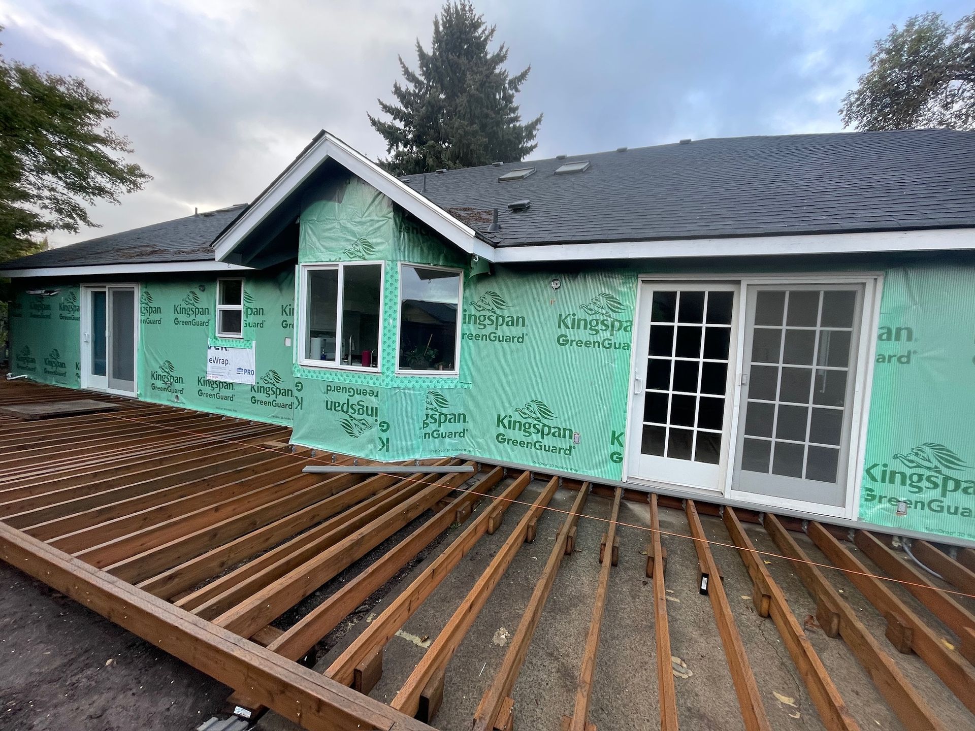 A house is being built with a wooden deck in front of it.