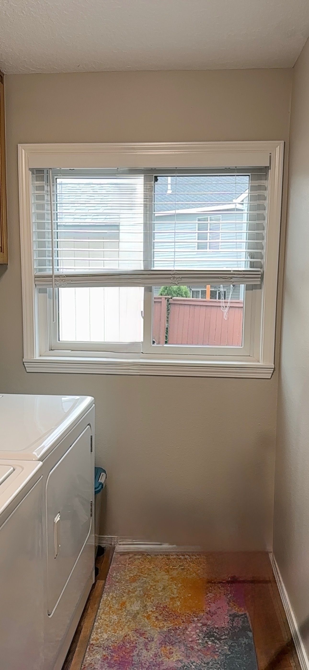 A laundry room with a washer and dryer and a window.