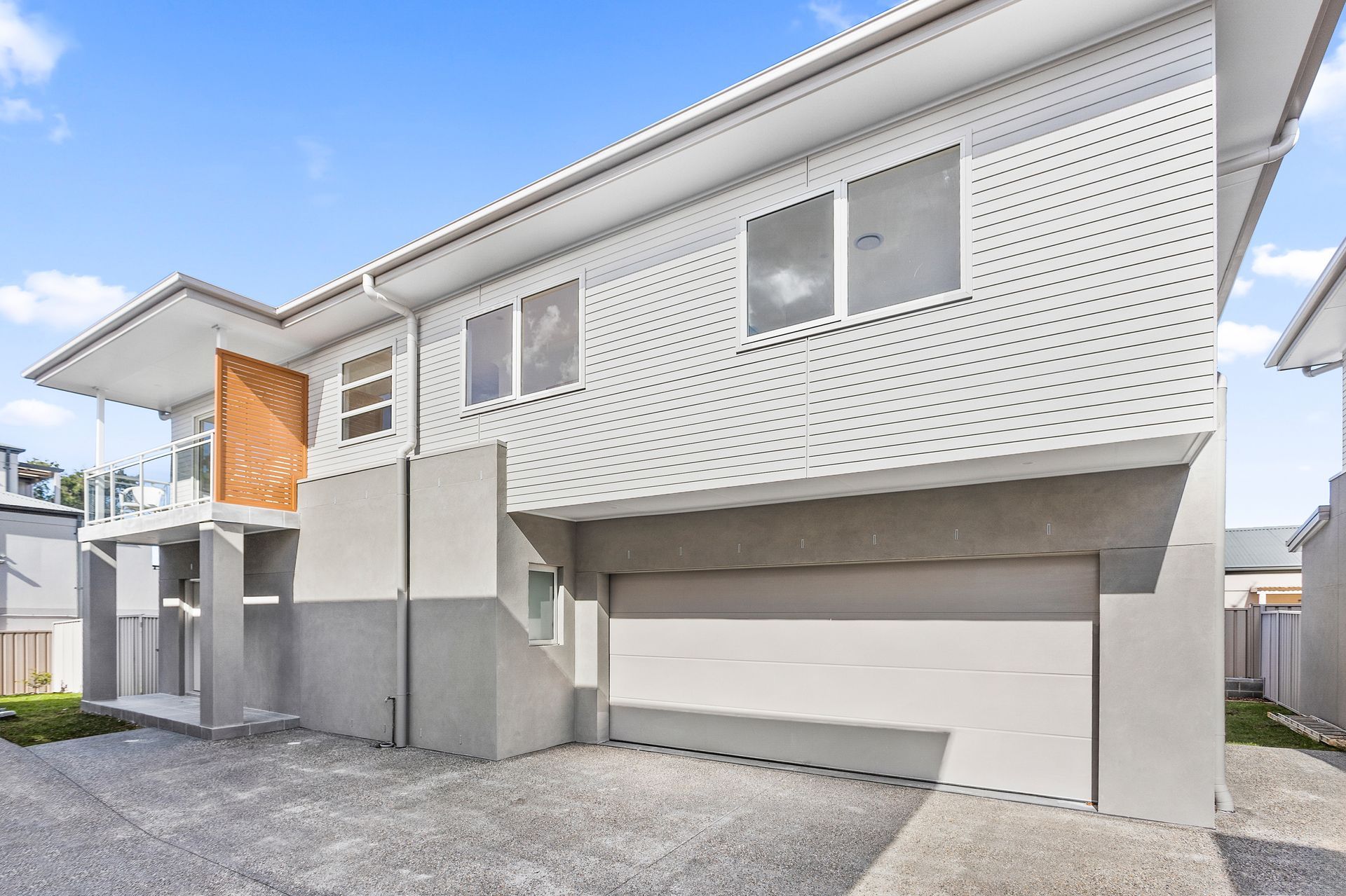 Two-story modern home with gray and white facade and attached garage.