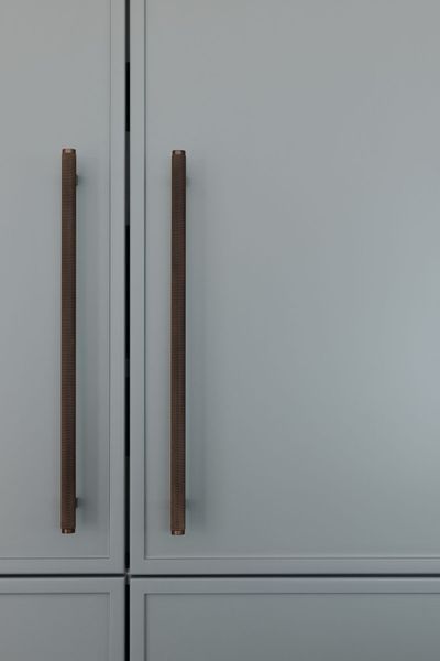 Two pale blue cabinet doors with vertical brown handles.