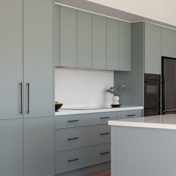 Modern kitchen with sage green cabinets, black appliances, and white countertops.