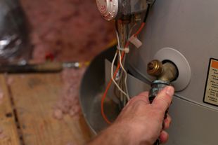 hvac repair technician installing new hot water heater