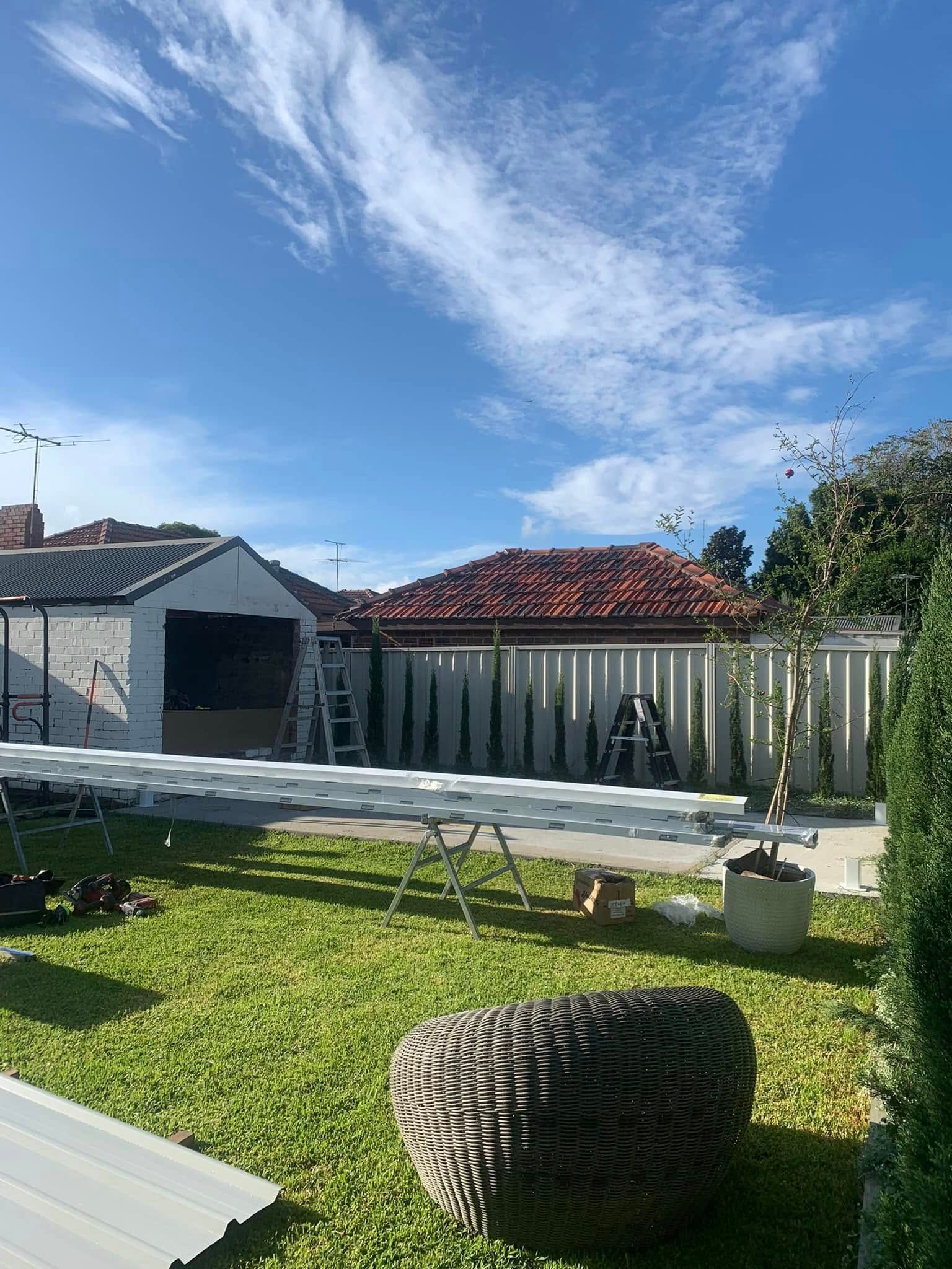 There is a ladder in the backyard of a house.