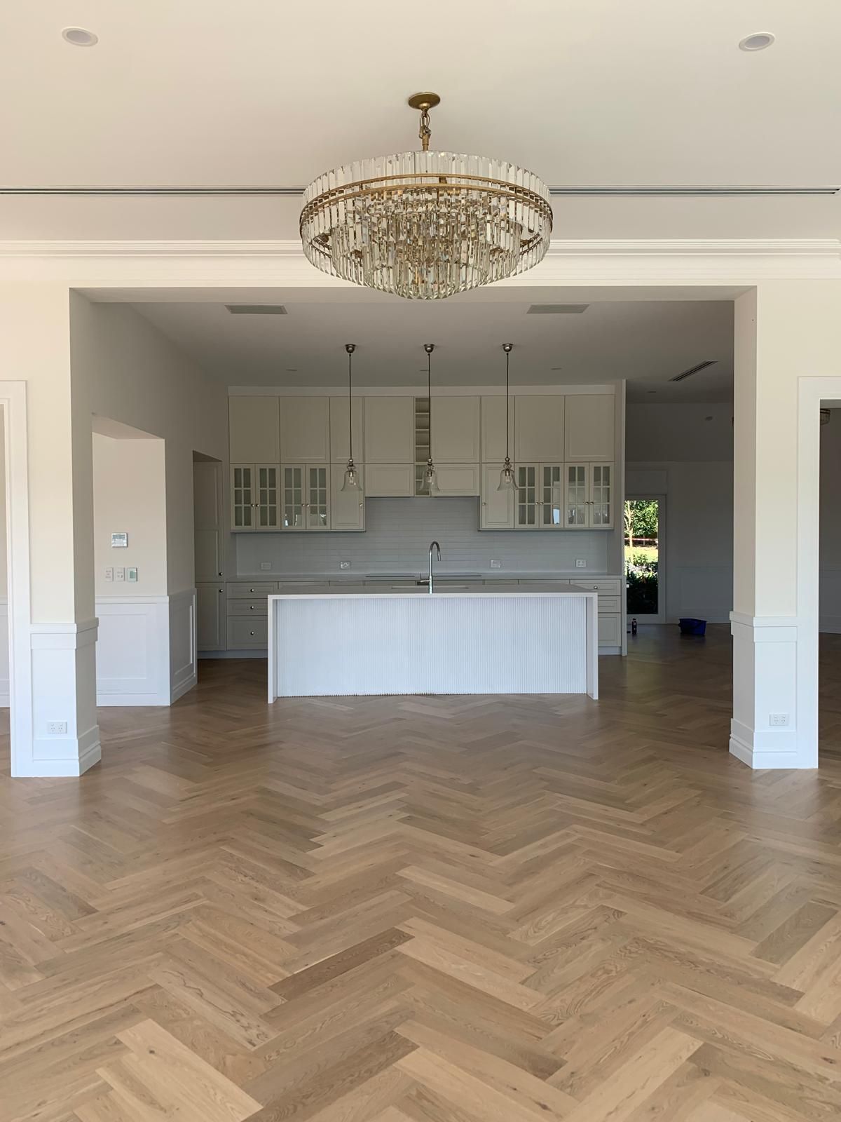A kitchen with a large island and a chandelier hanging from the ceiling.
