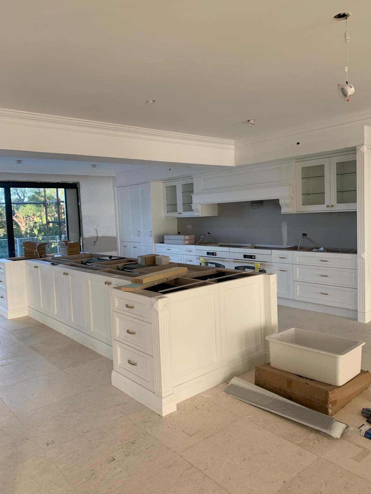 A large kitchen with white cabinets and a large island.