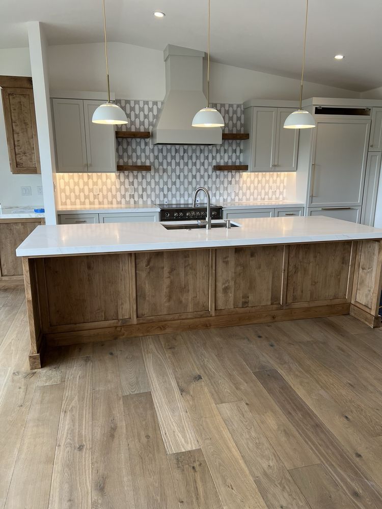 A kitchen with wooden cabinets and white counter tops