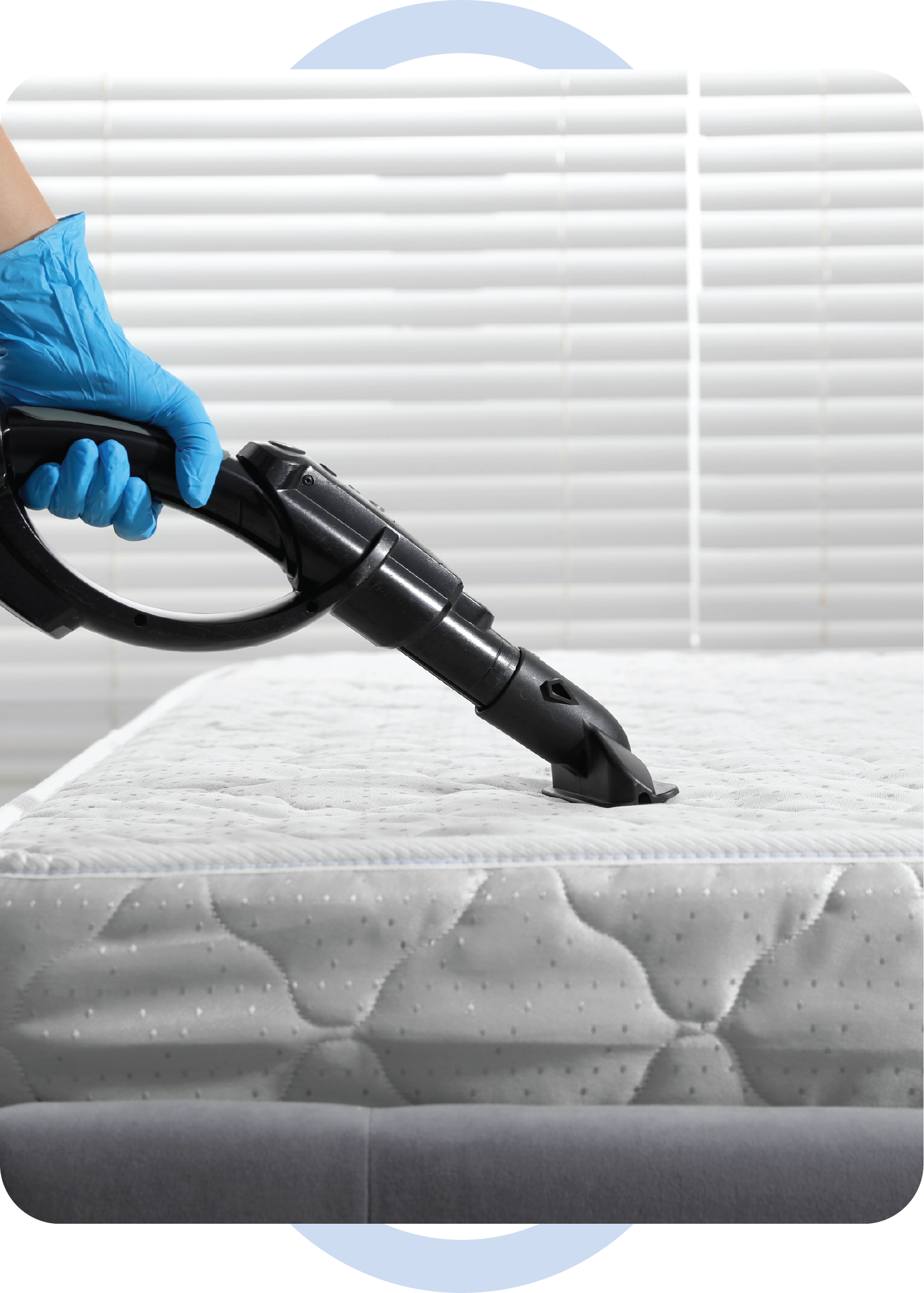 A person is cleaning a mattress with a vacuum cleaner.