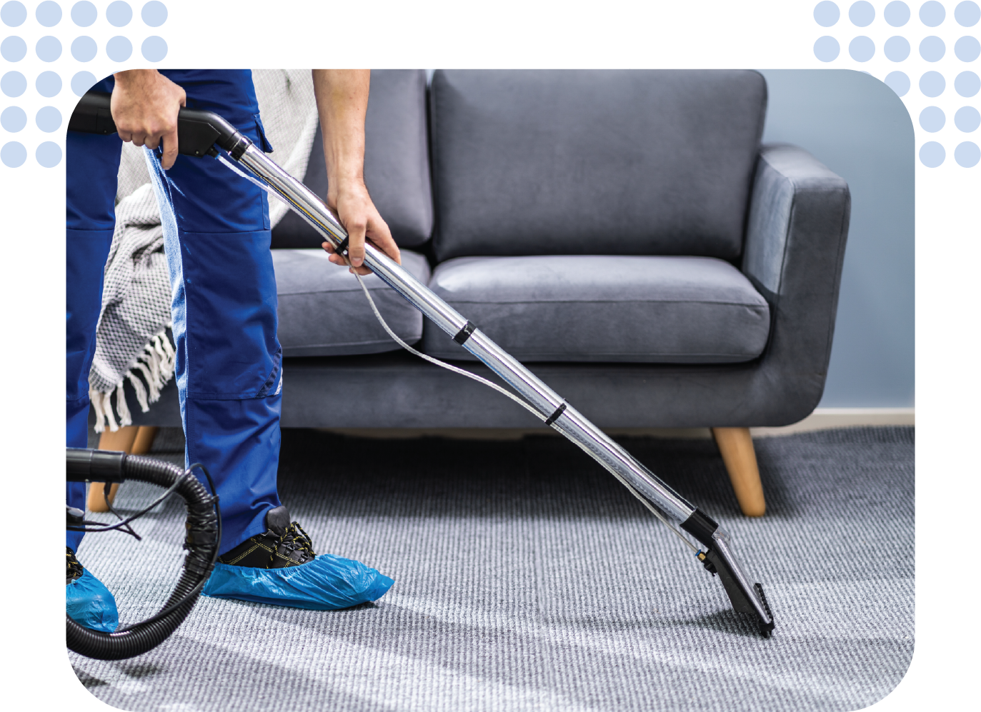 A man is cleaning a carpet with a vacuum cleaner in a living room.