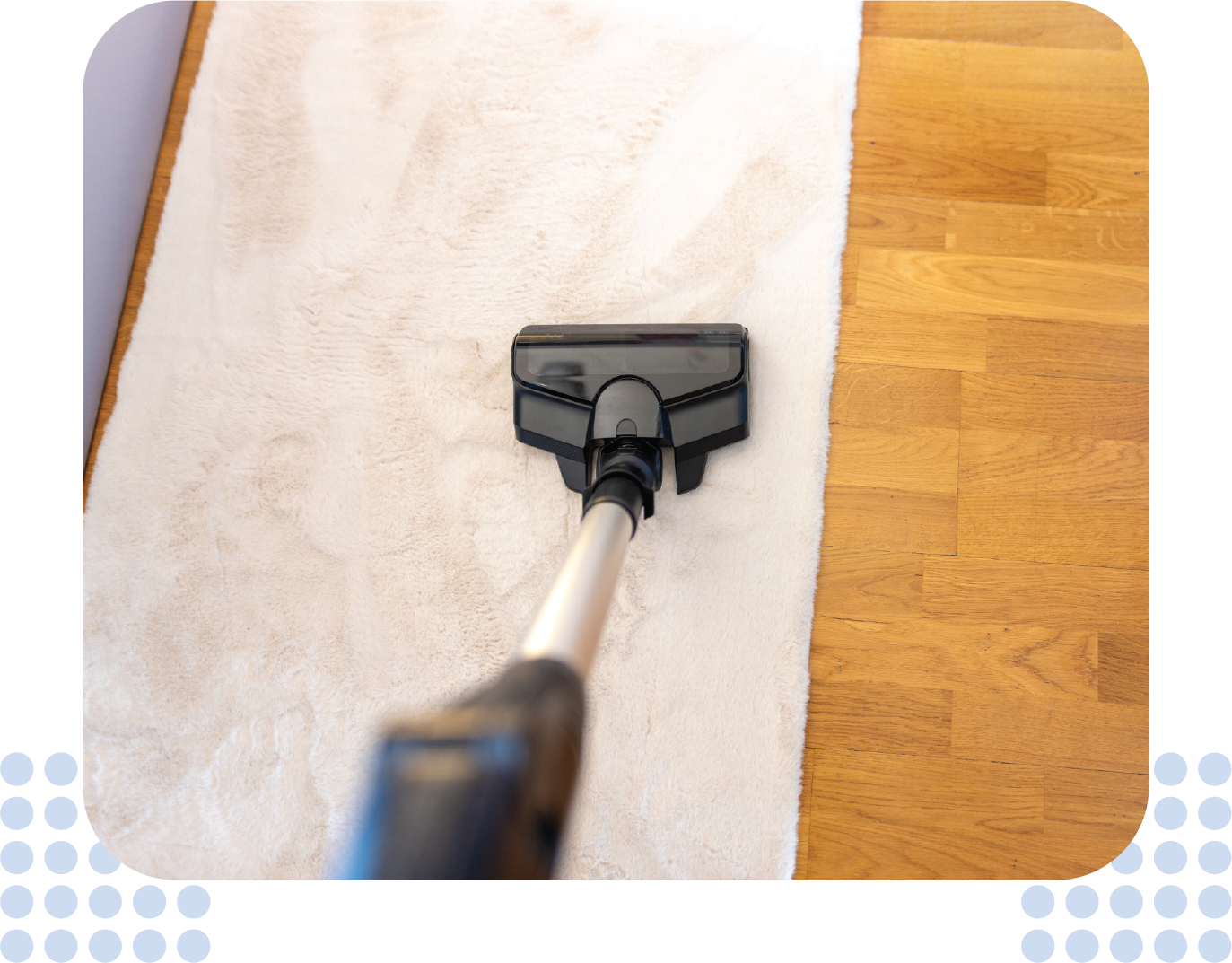 A vacuum cleaner is cleaning a white towel on a wooden floor.