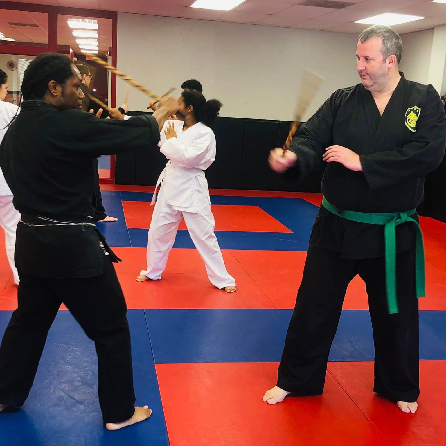 a man in a black karate uniform with a green belt