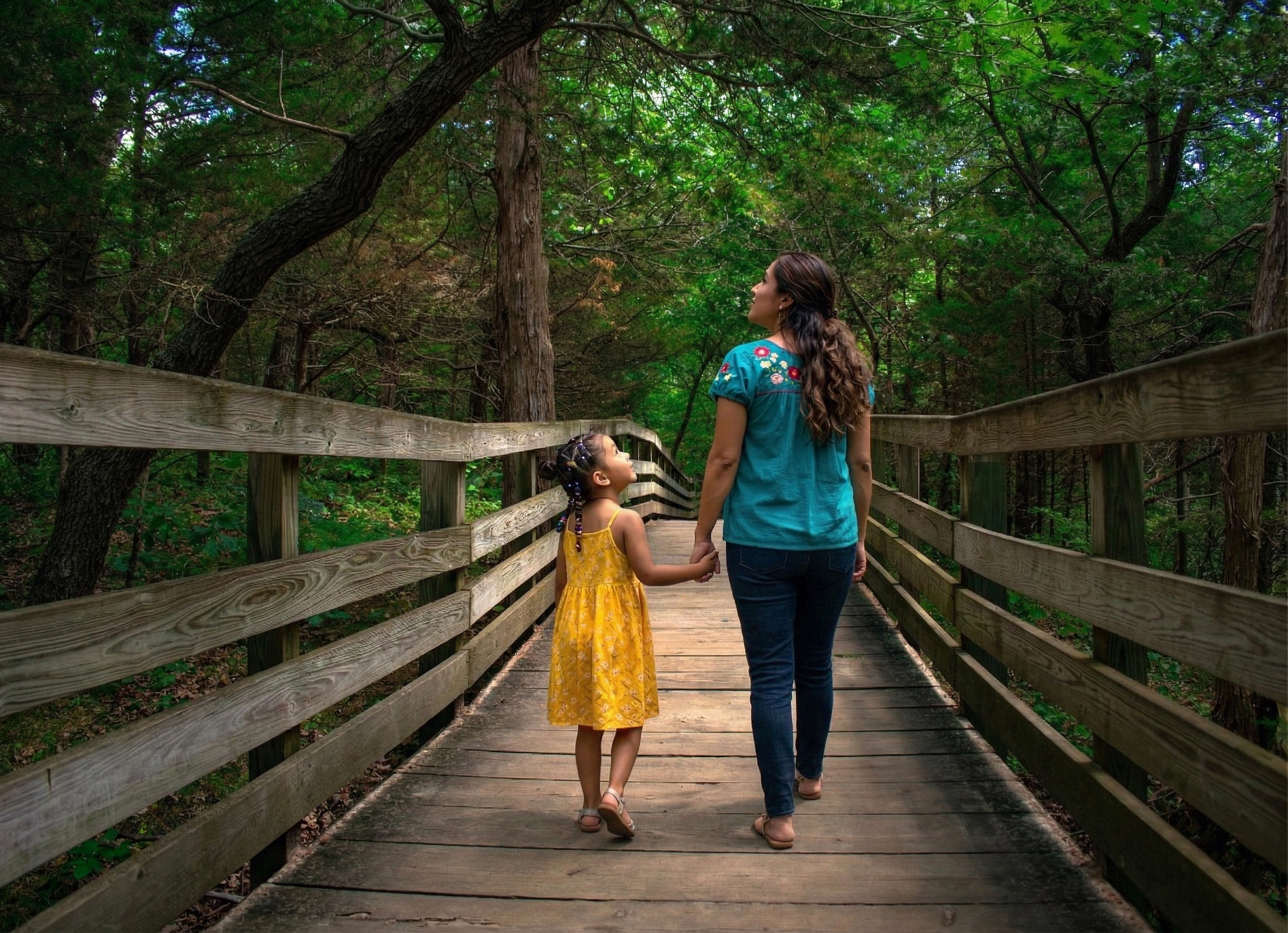 A woman is sitting on a couch talking to a little girl.