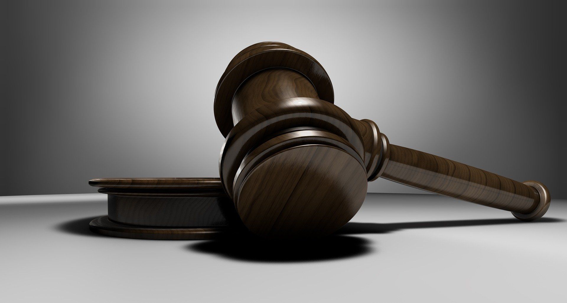 A wooden judge 's gavel sits on a white surface