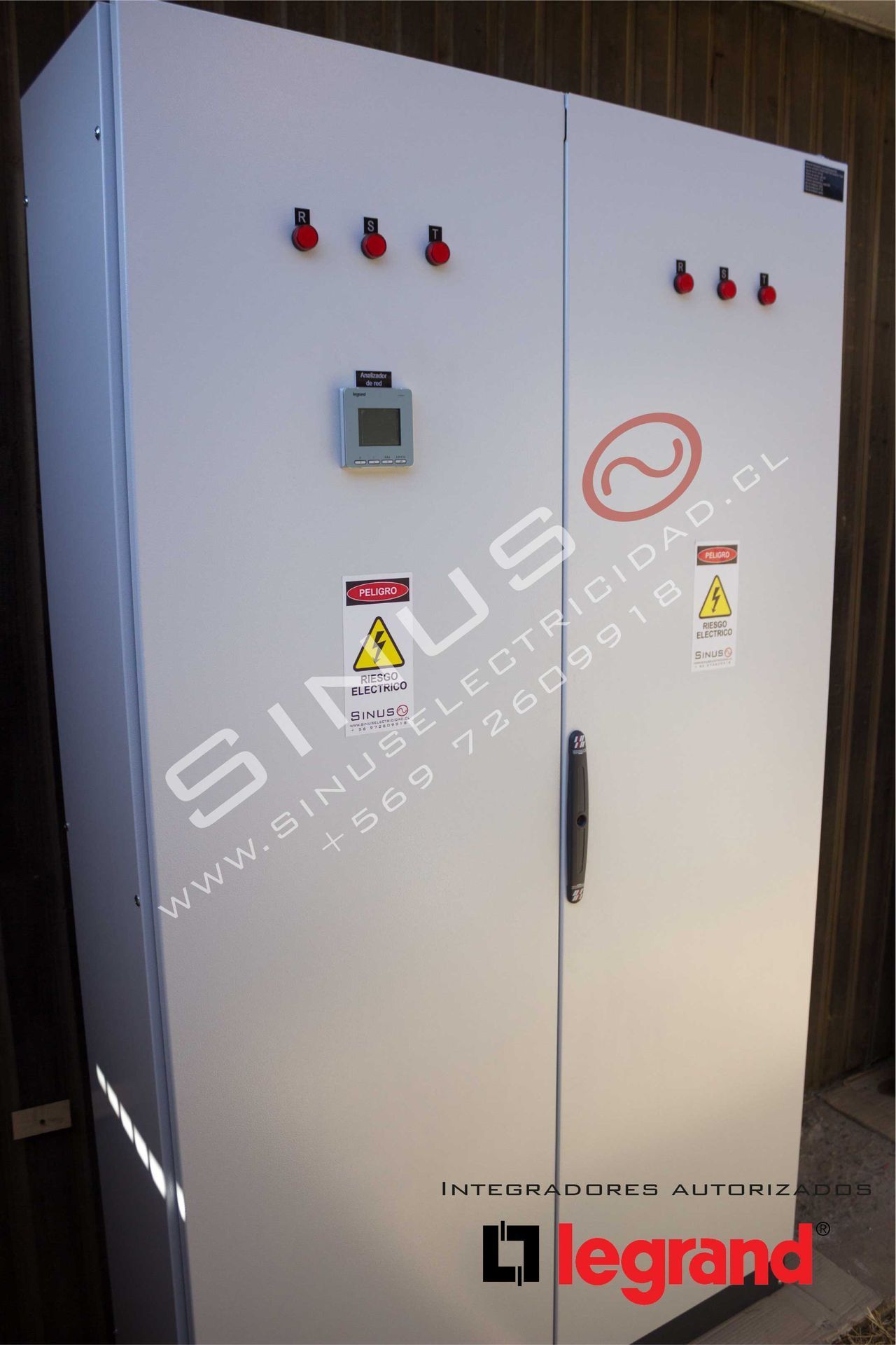 Armario eléctrico industrial blanco con señales de advertencia, interruptores rojos y un contador digital.