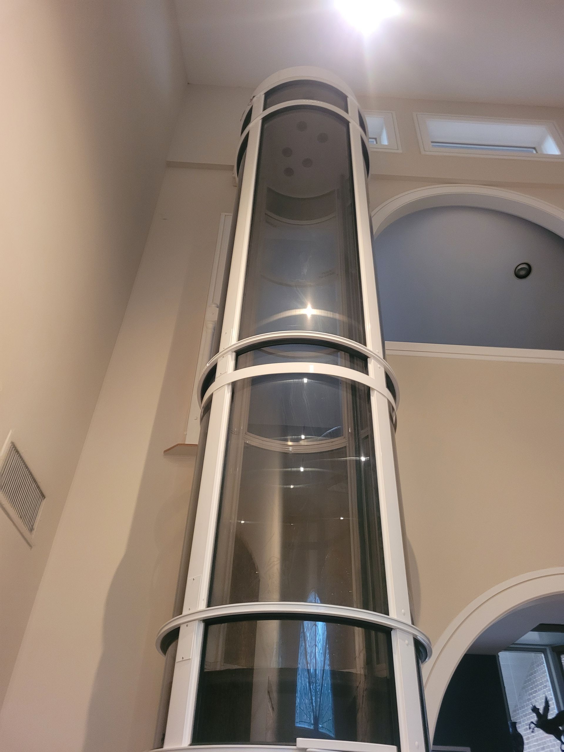 A large glass elevator is sitting in the middle of a room.
