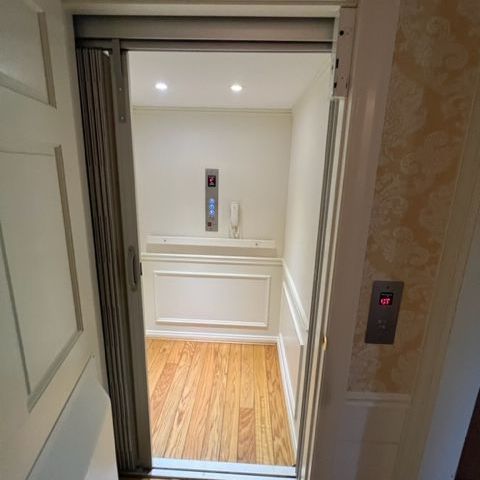A stair lift with a gray seat and a wooden railing
