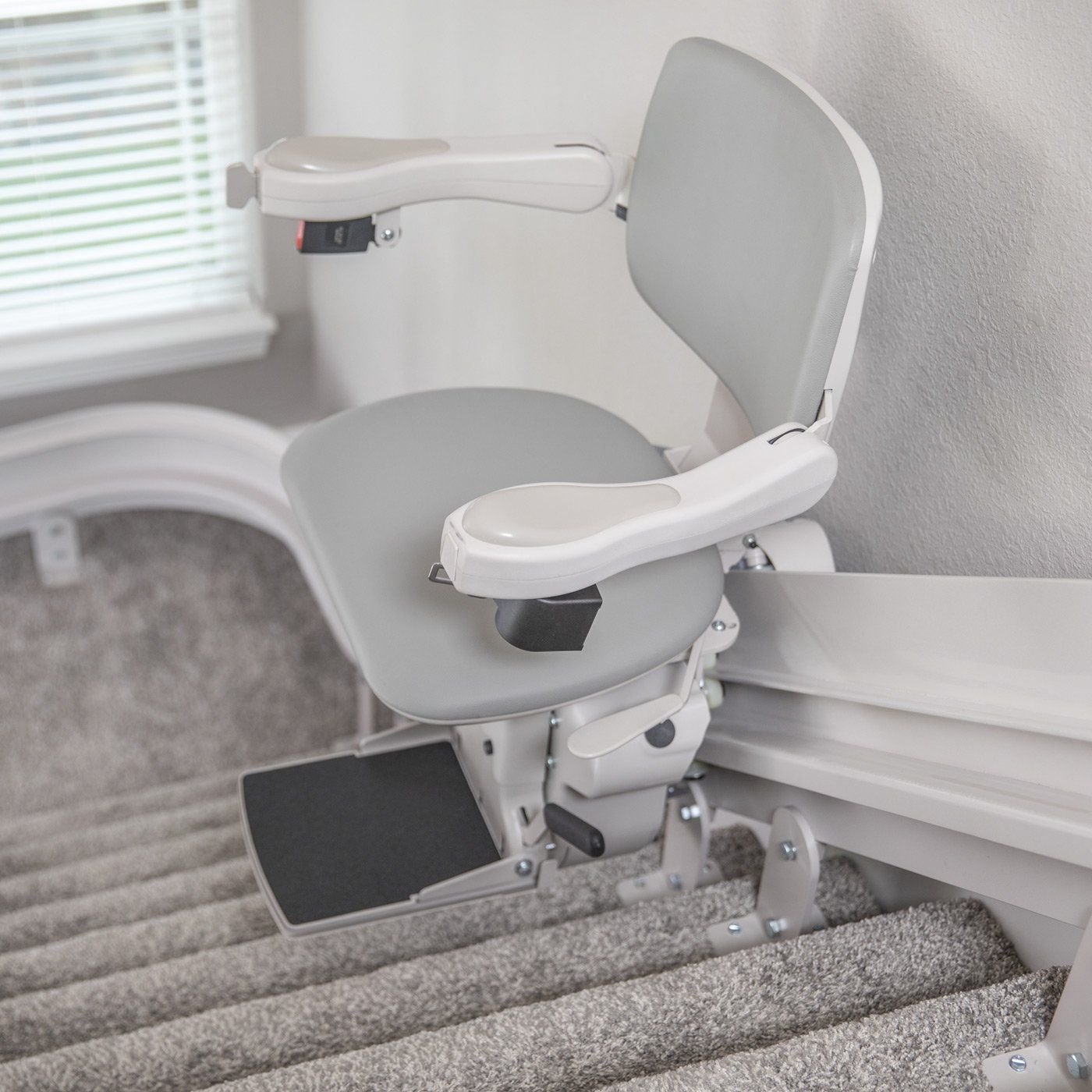 A stair lift is sitting on top of a set of stairs.