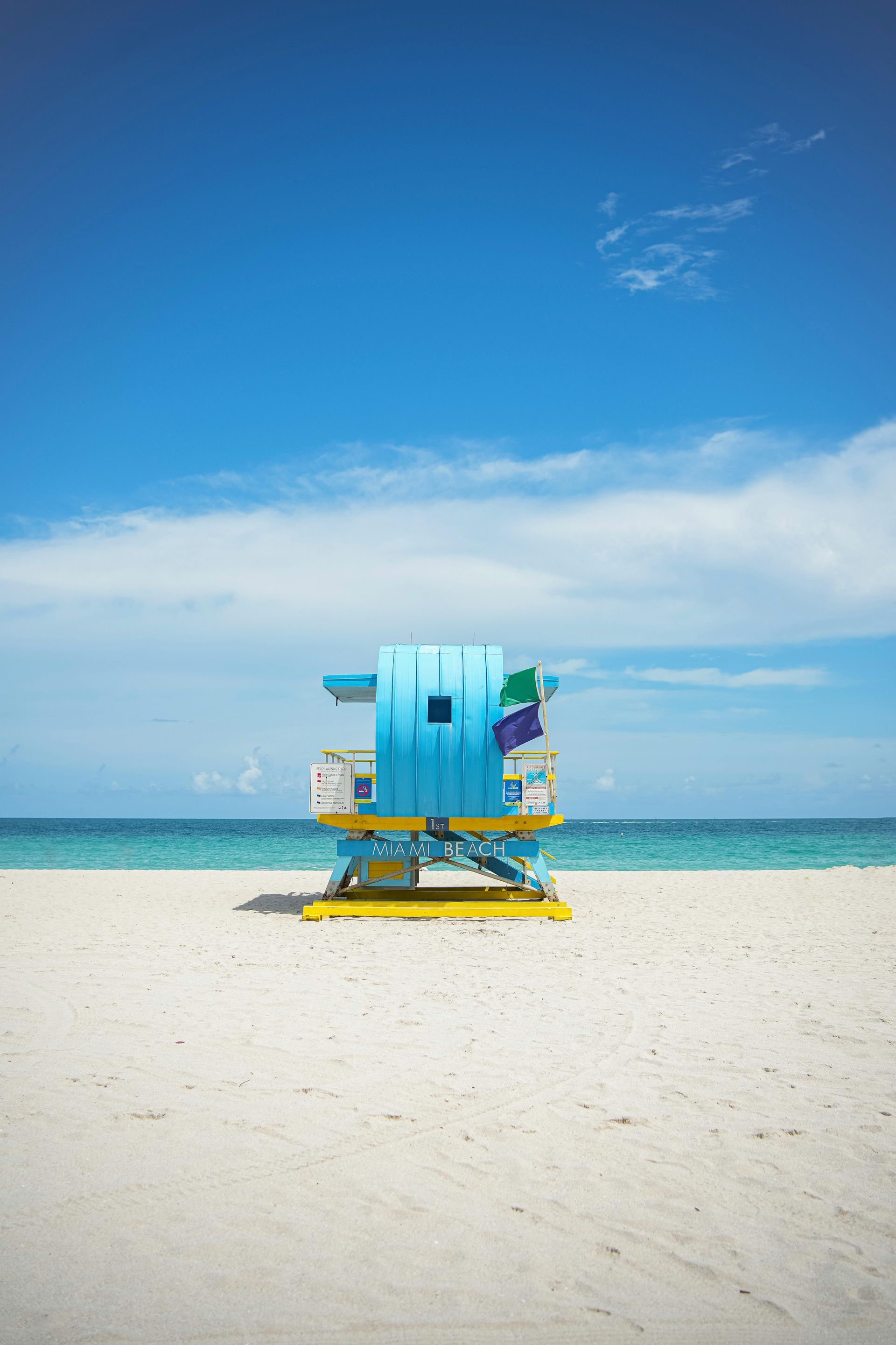 A lifeguard tower on a beach with a blue sky in the background