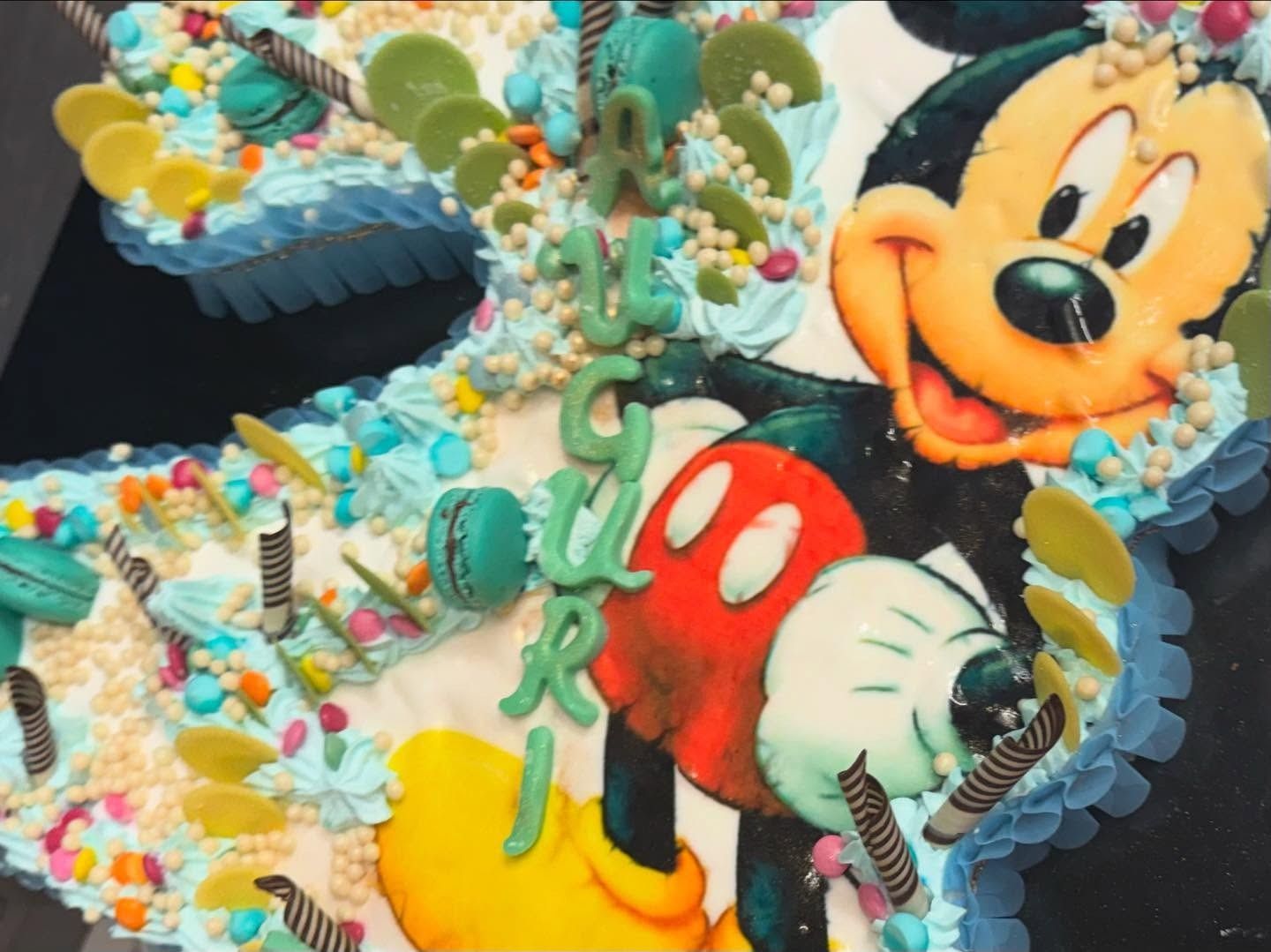 Torta di Topolino a forma di numero 2 con glassa colorata e decorazioni.