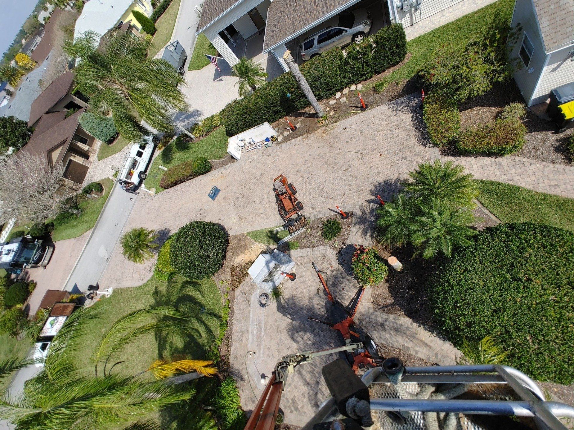 Overhead view of residential area with construction equipment on a driveway.