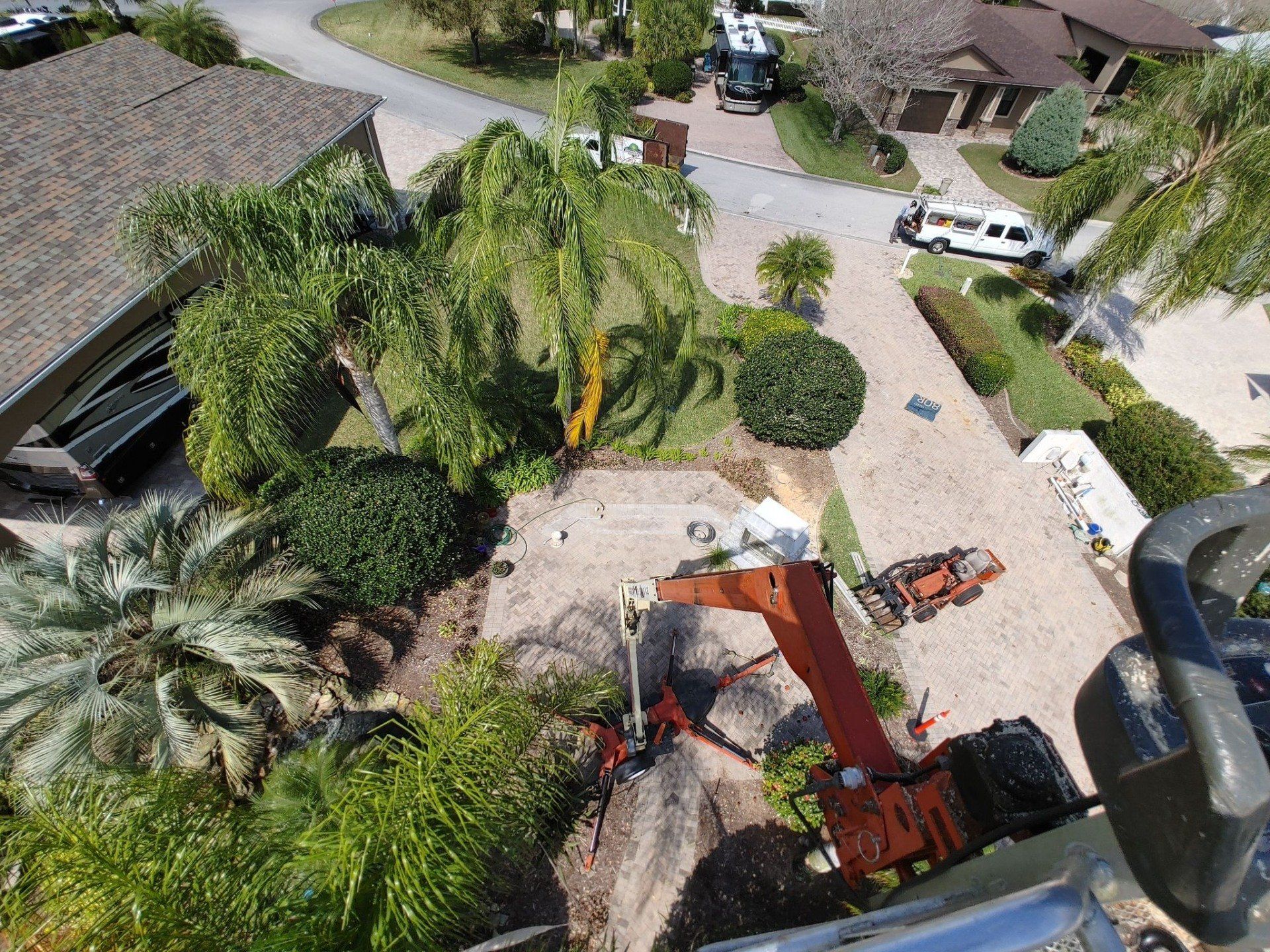 Aerial view of construction site with an excavator. Green landscaping surrounds.