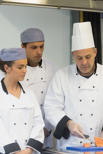 A group of chefs are preparing food in a kitchen