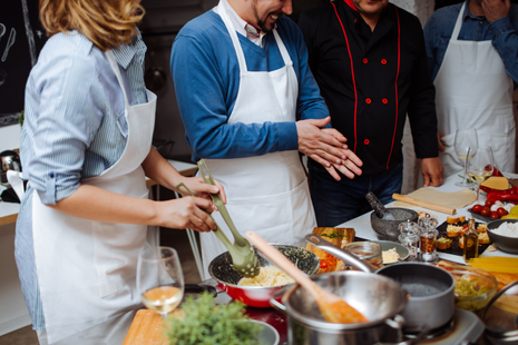 A group of people are cooking together in a kitchen.