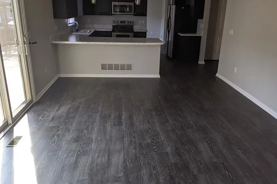 Open-concept kitchen and living room with dark wood-look flooring