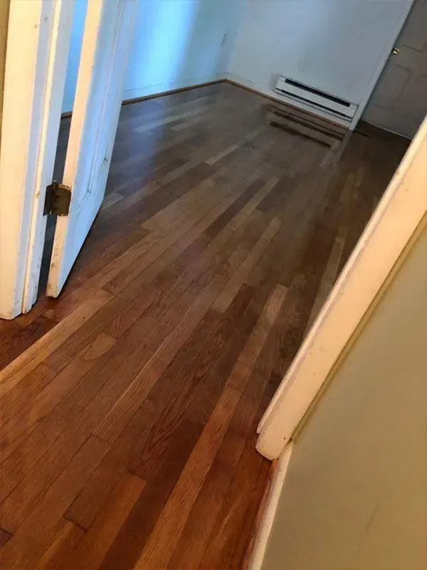 Wooden floors inside a room with a white doorway