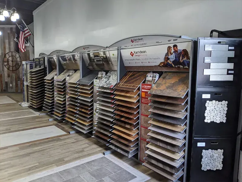 Display of flooring samples in a showroom, with multiple sample boards showcasing various tile and wood-look options.