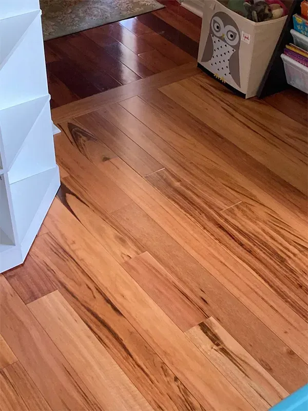 Hardwood floors transition from a dark brown to a lighter brown color