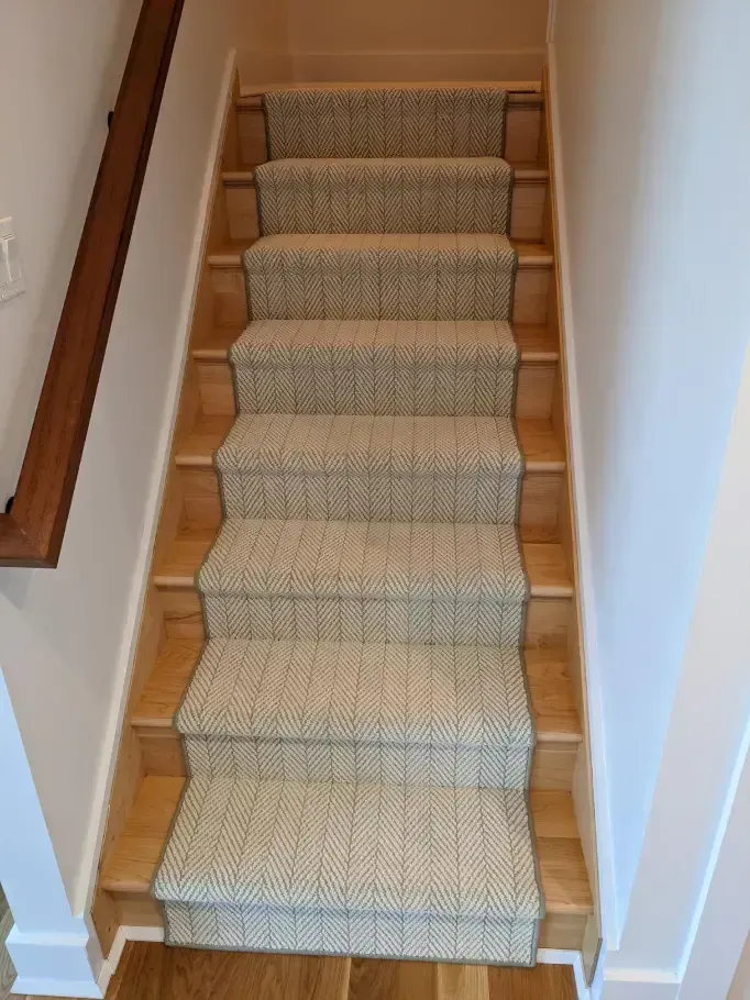 Staircase with wooden steps and a patterned carpet runner